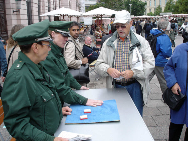 Police demonstrating a shell-game swindle near Checkpoint Charlie, Berlin, Germany