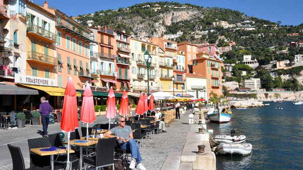 Sidewalk cafés lining the harborside of Villefranche-sur-Mer, France