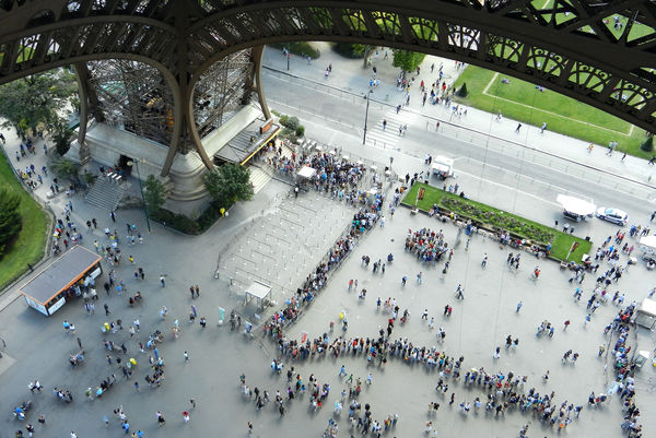 Ticket buyers waiting in line under the Eiffel Tower, Paris, France