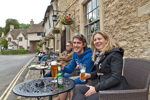 A couple drinking at a pub in the Cotswolds, England