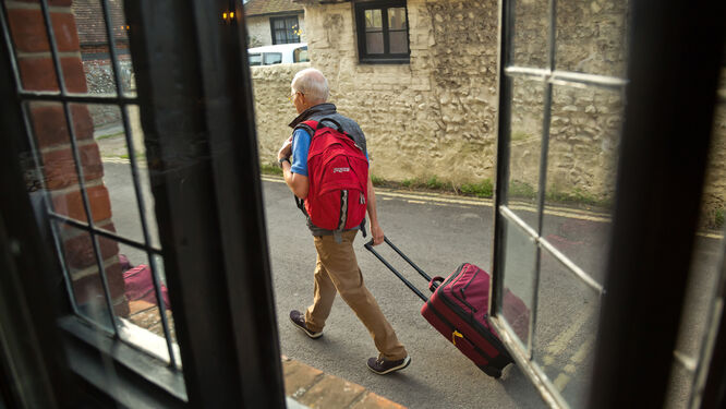 A man rolling his luggage in Alfriston, England