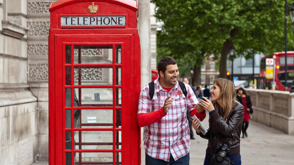 People next to a phone booth in London, England