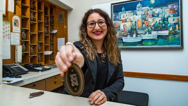 Woman holding keys at hotel reception desk