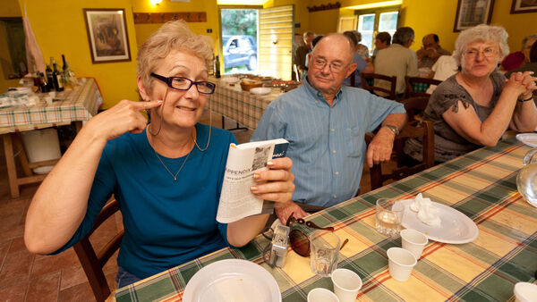 Woman making cheek gesture while reading guidebook