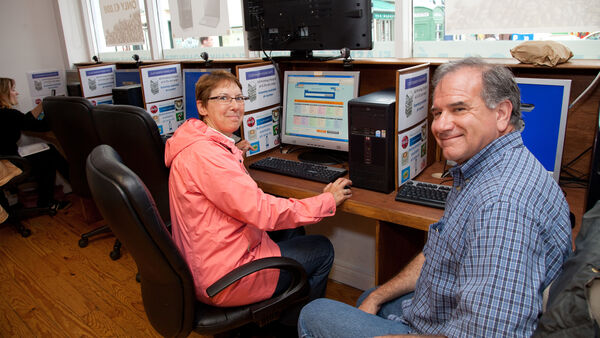 Couple using computer at internet cafe