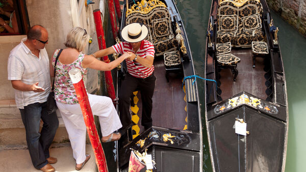 Tourist boarding a gondola, Venice