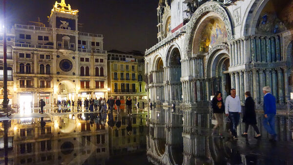 St. Mark's Square during acqua alta (flood) with Clock Tower and St. Mark's Basilica, Venice, Italy 