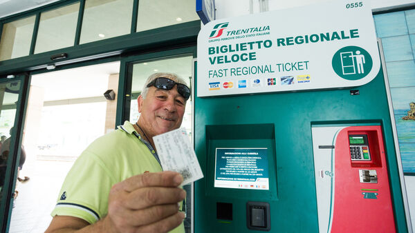 Man buying rail ticket at self-service machine, Sicily