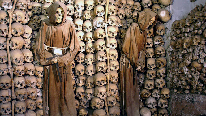 Neatly stacked skulls and robed monk skeletons in the Capuchin Crypt of Rome