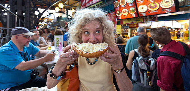 hungary-budapest-great-market-hall-lady-eating-langos