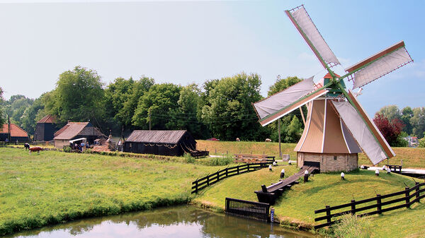 A traditional Dutch windmill near a pond at the Zuiderzee Museum near Enkhuizen, Netherlands