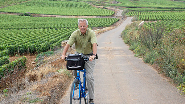 Rick's friend and co-author Steve Smith bike riding through Burgundian vineyards
