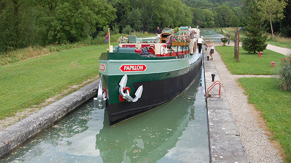 Traditional canal barge passing through a lock in Burgundy, France