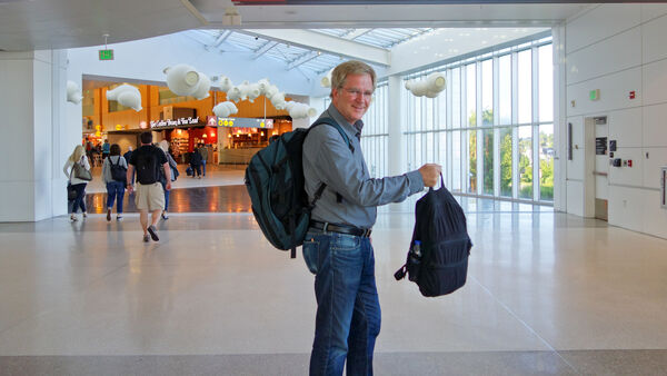 Rick Steves holding luggage at the airport