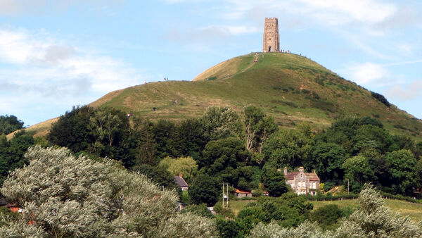 The terraced hill called Glastonbury Tor, topped by the medieval St. Michael's Tower, in Glastonbury, England