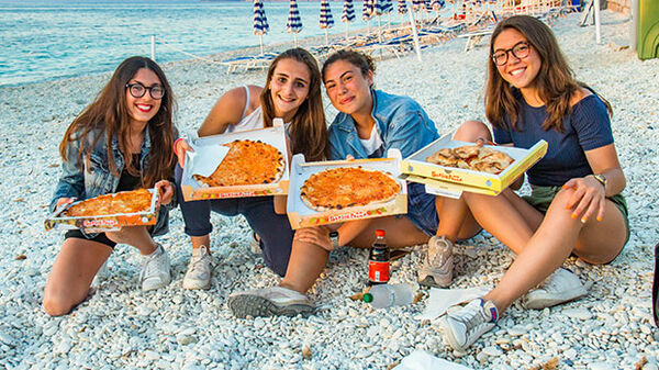 Girls with pizza at the beach