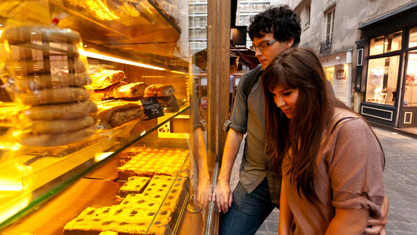 A young couple eyeing treats in a patisserie window in Paris