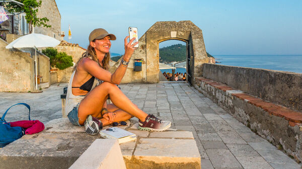 A woman savoring a scenic spot along Dubrovnik's city walls