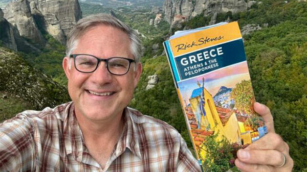 Cameron Hewitt holding Greece guidebook