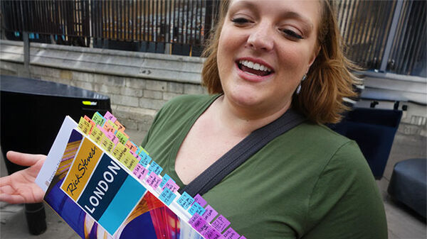 Girl with tabbed guidebook, London, England