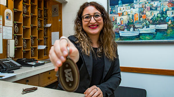 Smiling hotel reception woman with key, Vieste, Italy