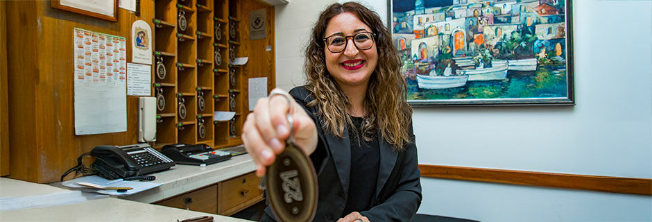 Smiling hotel reception woman with key, Vieste, Italy