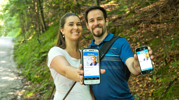 couple holding phones showing audio europe app