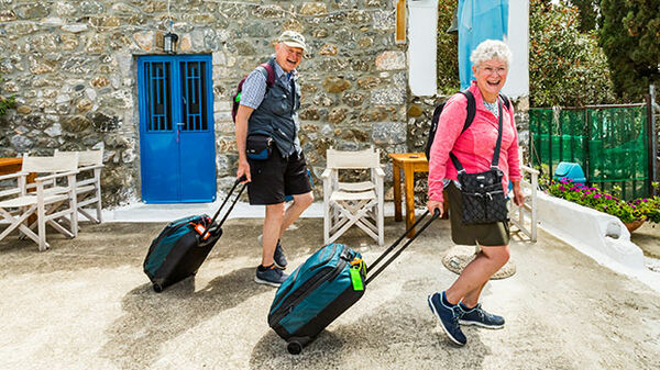 A couple rolling their luggage