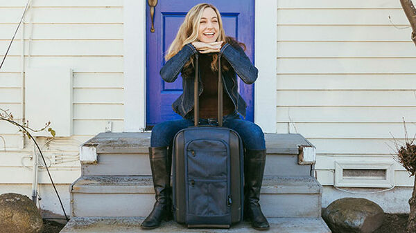 Lady sitting with the Riga Rolling Case luggage