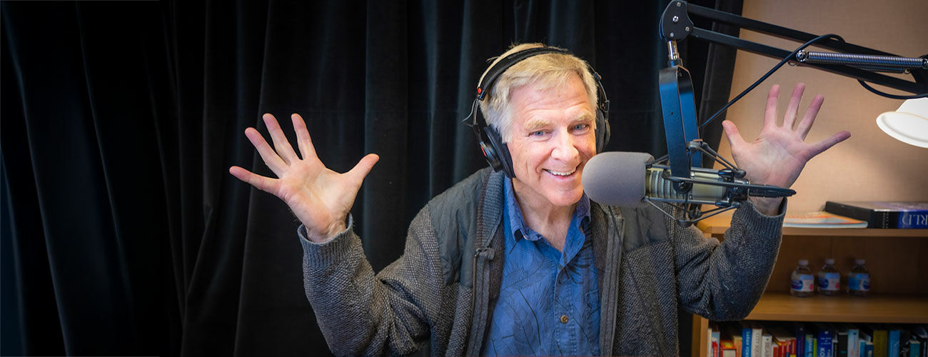 rick-steves-waving-his-hands-in-front-of-microphone-in-his-readio-studio