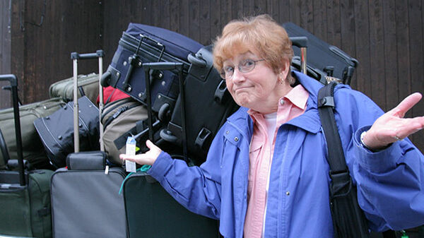 Lady in front of a pile of suitcases