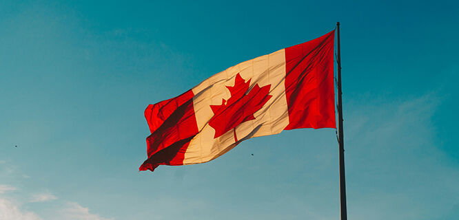 Canada flag flying against blue sky