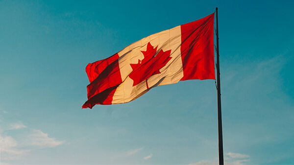 Canada flag flying against blue sky