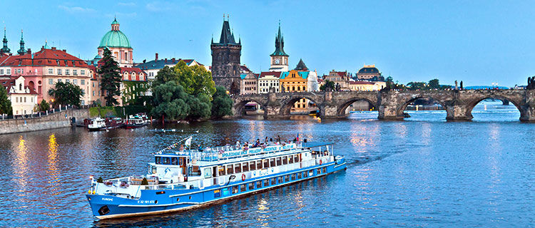 Boat and Charles Bridge on Vltava River, Prague, Czech Republic