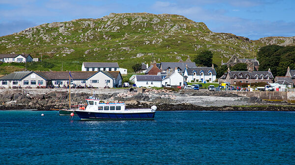 Water view of boat and village, Iona, Inner Hebrides, Scotland