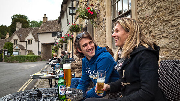 Couple outside pub, Cotswolds, England