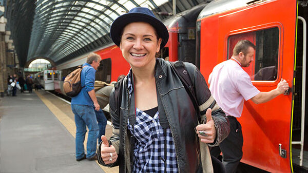 Woman giving thumbs-up at train station