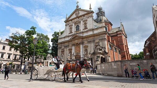 Square and horse-drawn carriage in daylight, Krakow, Poland