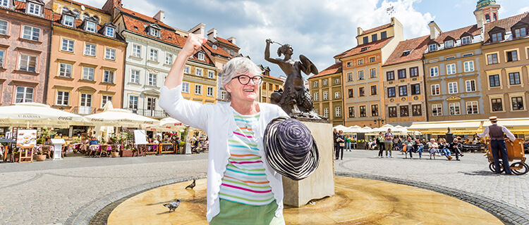 Woman copying mermaid statue pose, Old Town square, Warsaw, Poland