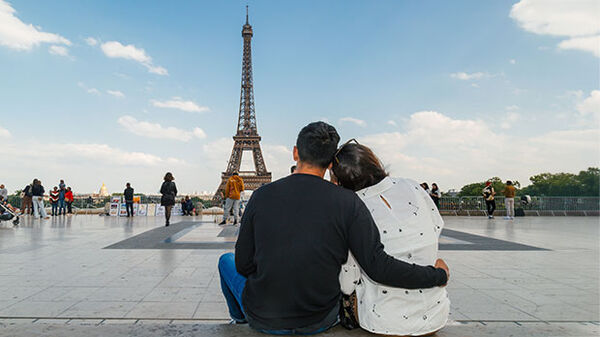 Couple facing Eiffel Tower, Paris, France