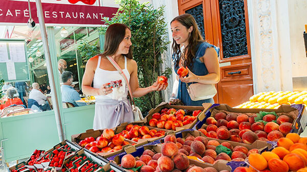 Two young women buying fruit, France