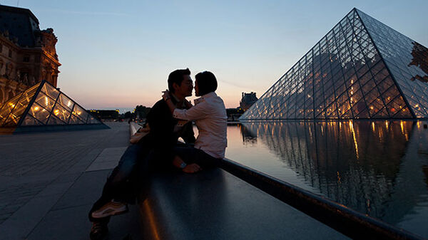 Couple at dusk outside Louvre, Paris, France