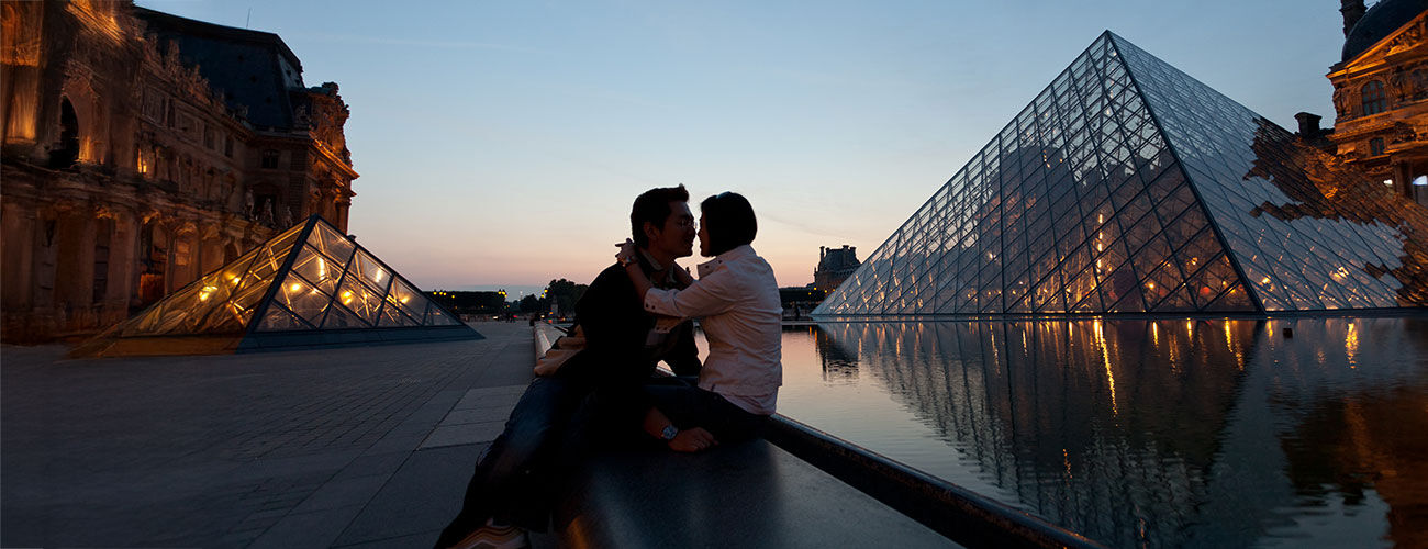 Couple at dusk outside Louvre, Paris, France
