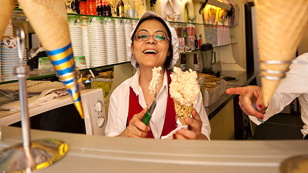 Smiling woman serving gelato, Florence, Italy