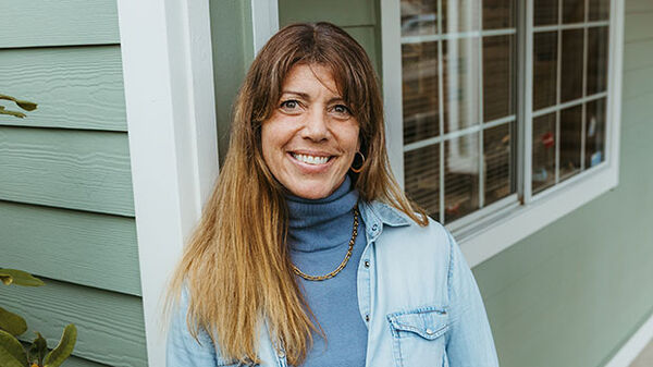 woman in front of blue house