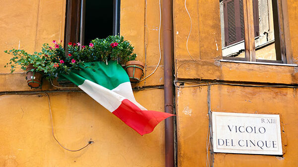 Italian flag waving from window, Rome, Italy
