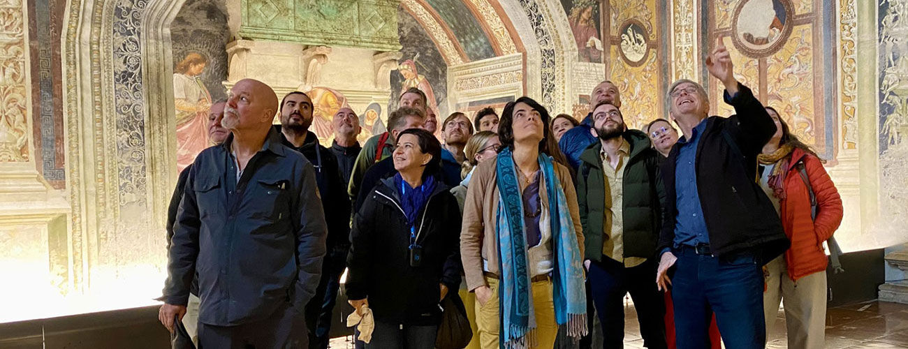 group of people looking at the paintings on a ceiling of a church