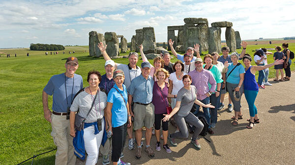group of travelers in front of stone circle