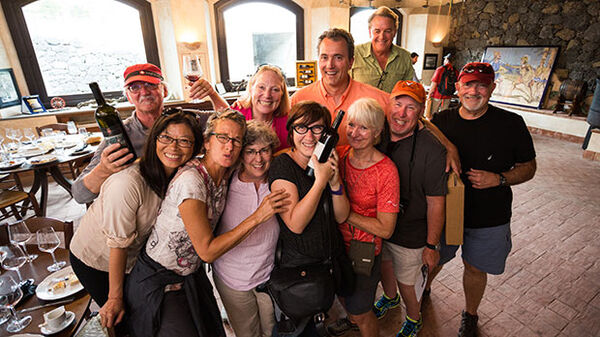 group of people drinking wine and toasting