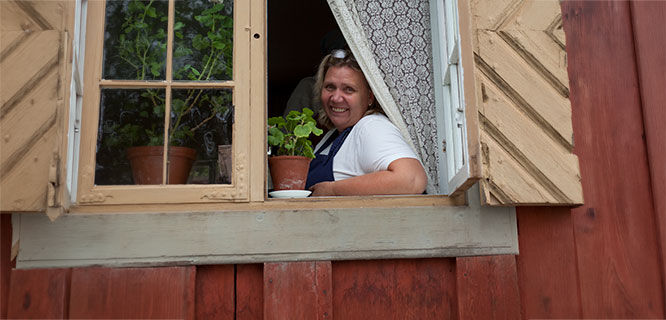 women looking out the window of a red cabin